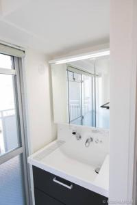 Un baño con lavabo y un espejo grande. en Origaminn 401 by b hotel - 5 mins Peace Park, en Hiroshima