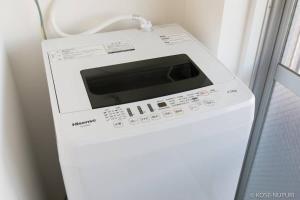 una lavadora blanca junto a una ventana en Origaminn 401 by b hotel - 5 mins Peace Park, en Hiroshima