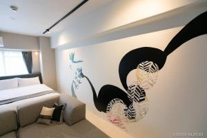 een slaapkamer met een zeemeermin muurschildering aan de muur bij bHOTEL Origaminn 401 - 5 mins Peace Park in Hiroshima