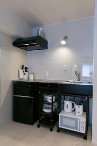 una cocina con encimera negra y fregadero en Origaminn 302 by b hotel - 5 mins PeacePark, en Hiroshima