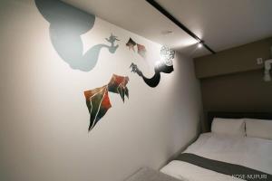Un dormitorio con una pared con pájaros pintados. en Origaminn 302 by b hotel - 5 mins PeacePark, en Hiroshima