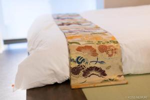 - un oreiller sur un lit avec une couverture dans l'établissement bHOTEL Origaminn 303 - 5 mins PeacePark, à Hiroshima
