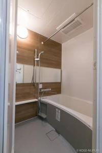 La salle de bains est pourvue d'une douche et d'un lavabo. dans l'établissement bHOTEL Origaminn 303 - 5 mins PeacePark, à Hiroshima