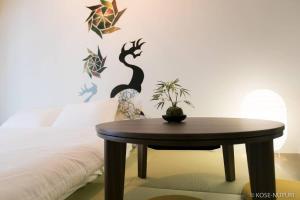 a table in front of a bed with a wall with aiger at Origaminn 403 by b hotel - 5 mins PeacePark in Hiroshima