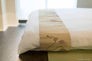 a close up of a bed with avertisement at Origaminn 403 by b hotel - 5 mins PeacePark in Hiroshima
