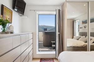 1 dormitorio con 1 cama y puerta corredera de cristal en Villa med fantastisk utsikt., en Tromsø
