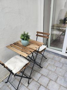 una mesa de madera con una maceta y 2 sillas en L'orchidée, en Verviers