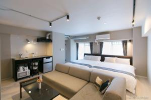 a bedroom with a large bed and a couch at bHOTEL Origaminn 601 - 5 mins PeacePark in Hiroshima