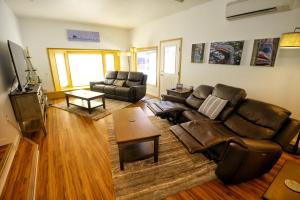 sala de estar con sofá de cuero y mesa en Green Valley Getaway - 3br Family Friendly Home, en Mendenhaven