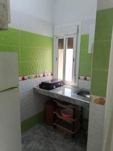 a small kitchen with a sink and a mirror at Good View Buena vista1 Good View Buena Vista2 Good View Buena Vista3 in Asilah