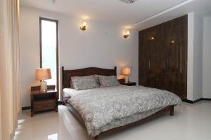 a bedroom with a large bed with two night stands and two lamps at Vista Valle in Murree