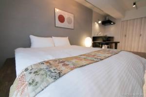 a bedroom with a large white bed in a room at bHOTEL Origaminn 603 - 5 mins PeacePark in Hiroshima