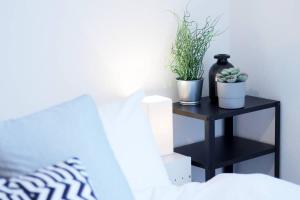 een zwarte nachtkastje met planten naast een bed bij b hotel Ball Park - 2mins walk Baseball 5mins walk Hiroshima Sta in Hiroshima +40 foto's