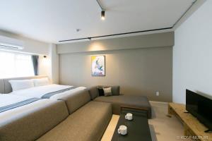 広島市にあるOrigaminn 701 by b hotel - 5 mins PeaceParkの大きなベッドとソファのある寝室 +30枚の写真