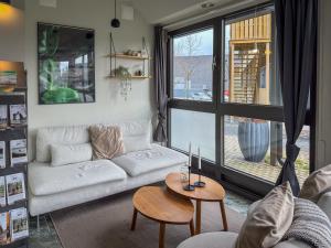 uma sala de estar com um sofá branco e uma mesa em HOOM Home & Hotel Jönköping em Jönköping