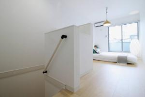 a white bedroom with a bed and a window at b hotel Ball Park - NewlyBuild 2 bedrm Apt 2 mins Baseball Museum 4ppl in Hiroshima
