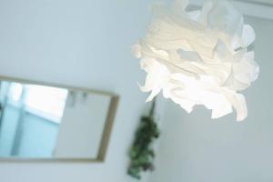 een witte papieren bloem die aan een muur hangt bij b hotel Ball Park - 2mins walk Baseball 5mins walk Hiroshima Sta 4ppl in Hiroshima