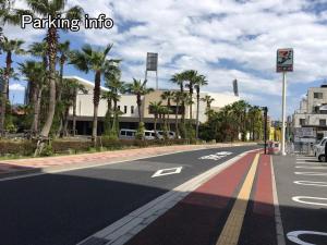 an empty street with palm trees and a building at bHOTEL Ball Park - 2mins walk Baseball 5mins walk Hiroshima Sta 4ppl in Hiroshima