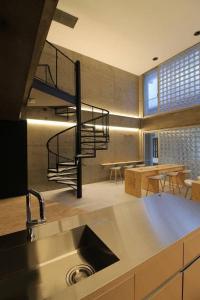 a kitchen with a sink and a spiral staircase at bHOTEL New Small Hotel - Hondori shopping arcade in Hiroshima