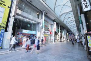 um grupo de pessoas andando em um shopping center em bHOTEL New Small Hotel - Hondori shopping arcade em Hiroshima