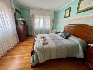 a bedroom with a bed with blue walls and wooden floors at Casa Amelia Noia in Noya