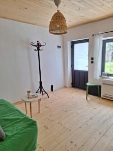 een grote woonkamer met een houten vloer en een lamp bij Под шарената сянка in Kŭrpachevo