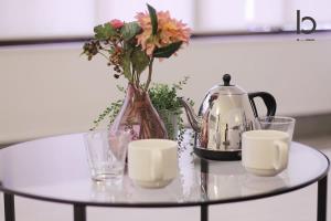 a glass table with a tea kettle and flowers on it at Hanagin - Beautiful Apartment for 6people with free wifi 102 in Hiroshima