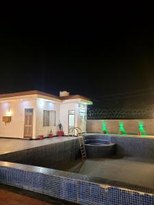 a house with a swimming pool at night at Marks Farm in Alwar