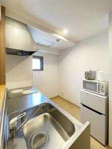 een keuken met een wastafel en een magnetron bij bHotel 560 Comfy Elegant 1BR apartment for 4 people in Hiroshima