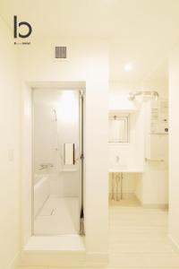 baño blanco con ducha y lavamanos en Hanagin - 3 Bedroom Japanese apartment for 11 people 201, en Hiroshima