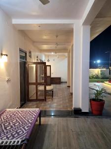 Cette chambre dispose d'un lit et d'un couloir avec une table. dans l'établissement Marks Farm, à Alwar