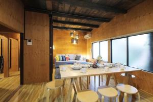 a room with a table and chairs and a couch at Nishikaniya by b hotel - Large Apartment 10mins walk from Hiroshima Station in Hiroshima