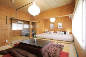 a bedroom with a bed and a couch and a table at Nishikaniya - Large Apartment 10mins walk from Hiroshima Station in Hiroshima +48 photos