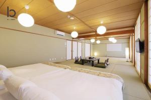 ein großes Zimmer mit einem Bett und einem Tisch in der Unterkunft Hanagin by b hotel - Large 2 bedroom apartment for 12people 301 in Hiroshima