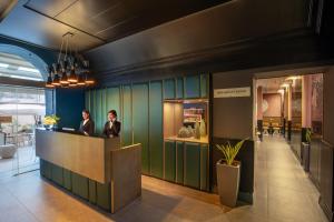 two people sitting at a counter in a lobby at The Guardian in Rome