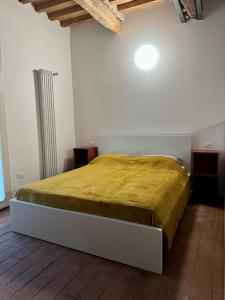 a bedroom with a bed with a yellow blanket on it at Casa Viaggi in Castel Guelfo di Bologna