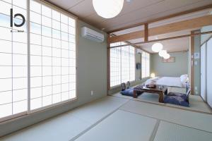 um quarto de hospital com uma cama e janelas grandes em Hanagin - Spacious 2 bedroom Japanese Apt for 10 ppl 401 em Hiroshima