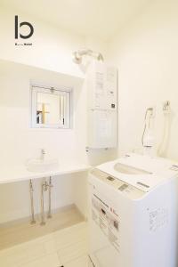 a white bathroom with a sink and a counter at Hanagin - Spacious 2 bedroom Japanese Apt for 10 ppl 401 in Hiroshima