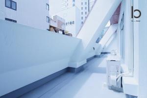 um corredor de um edifício com pisos brancos e escadas em Hanagin - Spacious 2 bedroom Japanese Apt for 10 ppl 401 em Hiroshima