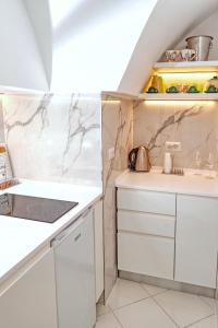 a kitchen with white cabinets and marble walls at O' Murzillo in Capri