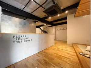 廿日市bHOTEL Kaniwasou 101 1BR good for 10PPL in the scenic Island of Miyajima的一间房间,有一个柜台,上面有读取脱鞋的标志