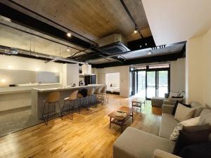 ein Wohnzimmer mit einem Sofa und einer Küche in der Unterkunft bHOTEL Kaniwasou 101 1BR good for 8PPL in the scenic Island of Miyajima in Hatsukaichi