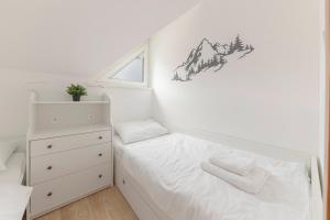 een kleine slaapkamer met een bed en een dressoir bij Cadys Apartment in Kranjska Gora