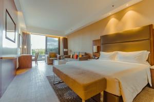 ナイロビにあるクラウン プラザ ナイロビ エアポートの大きなベッドとリビングルームが備わるホテルルームです。