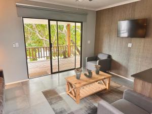 a living room with a coffee table and a balcony at Mukumbura Lodge Bilene in Vila Praia Do Bilene