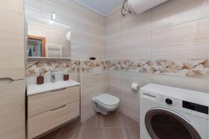 łazienka z toaletą, pralką i suszarką w obiekcie Cadys Apartment w mieście Kranjska Gora