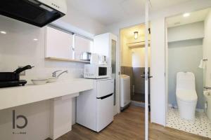 a white kitchen with a sink and a microwave at IS bld 201 by b hotel - Spacious Studio Apt for 4ppl Close to Peace Park in Hiroshima +25 photos