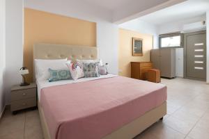 - une chambre dotée d'un grand lit avec des draps et des oreillers roses dans l'établissement Artoria Apartment 1 Groundfloor, à Haraki