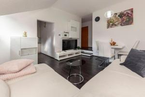een woonkamer met een witte bank en een tafel bij Cadys Apartment in Kranjska Gora