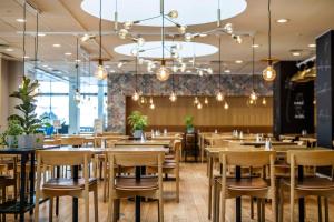 a restaurant with wooden chairs and tables and chandeliers at Scandic Copenhagen in Copenhagen